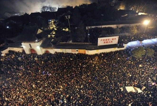 Прихожане в очереди у входа в буддийский храм Гуиян в Ухань чтобы совершить подношение на пятый день китайского Нового года