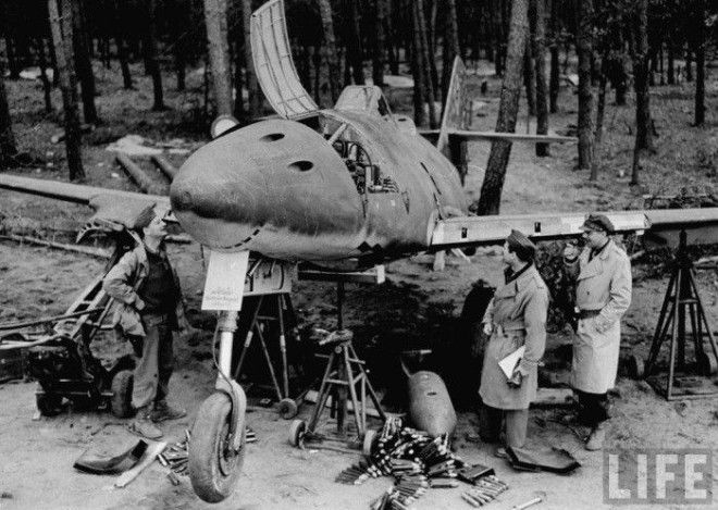 Армейские офицеры осматривают немецкий реактивный самолет который был сбит на Франкфуртском аэродроме