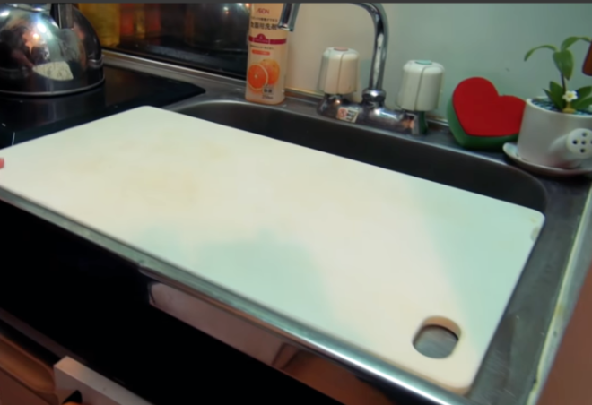 Вместо столешницы девушка использует разделочную доску установленную на раковине Фото youtubecom